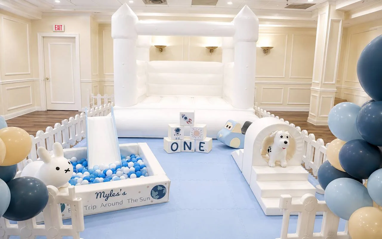 Blue space-themed premium soft play setup with an XL white bounce house