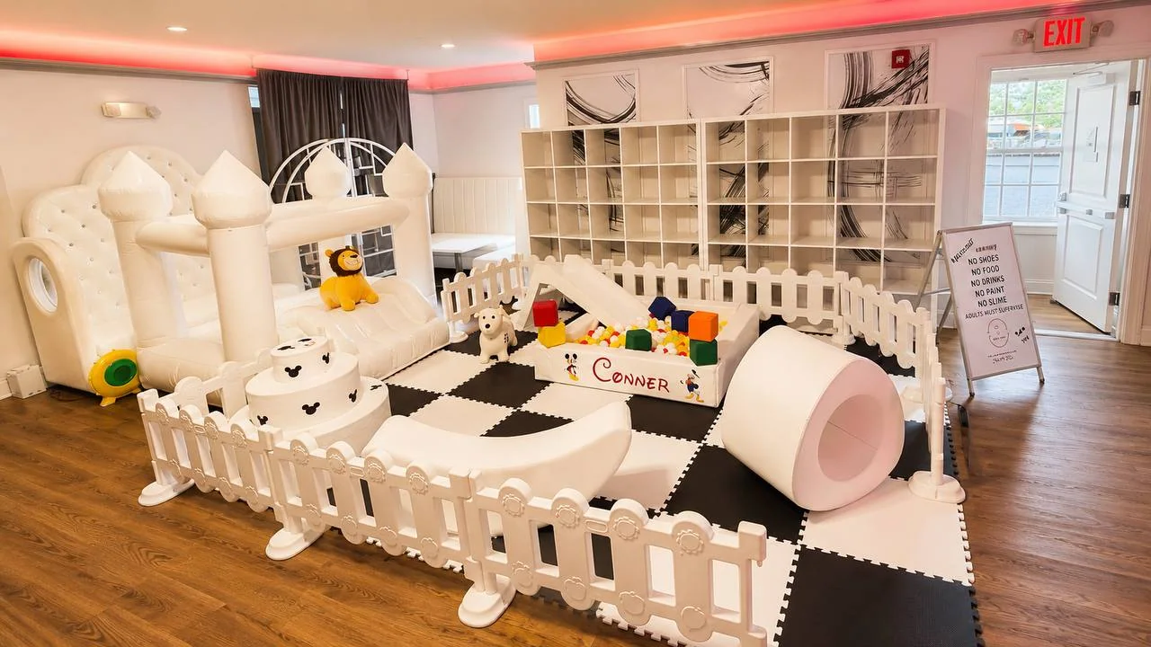 Indoor soft play party with checkerboard flooring and bounce house
